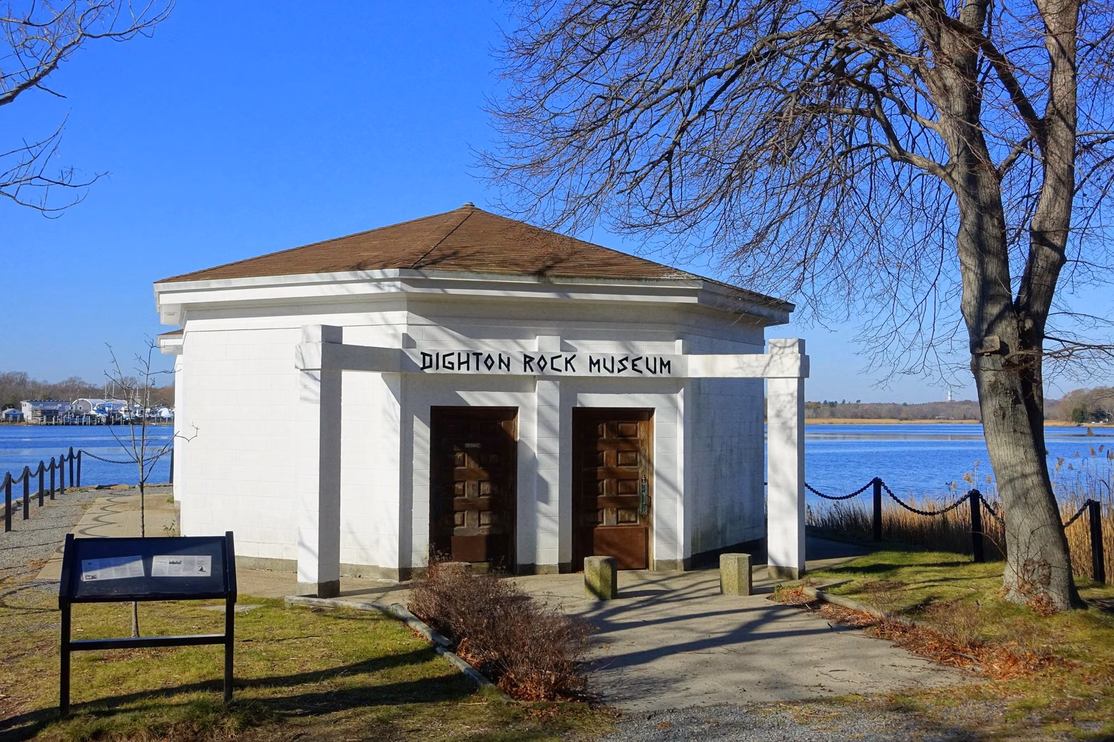 The small white Dighton Rock Museum building on the bank of the Taunton River, Berkley